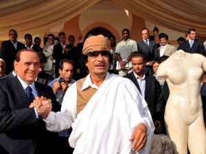 Gadafi y Berlusconi se dan la mano